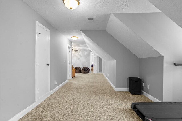 bonus room featuring carpet, a textured ceiling, and vaulted ceiling