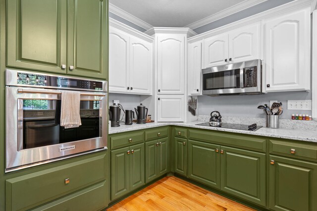 kitchen with white cabinets, stainless steel appliances, and ornamental molding