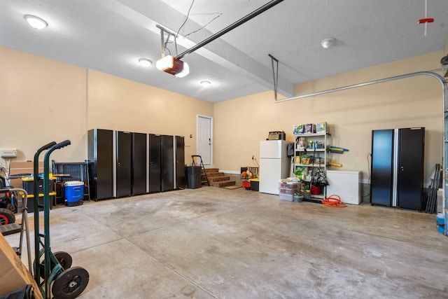 garage featuring white refrigerator and a garage door opener