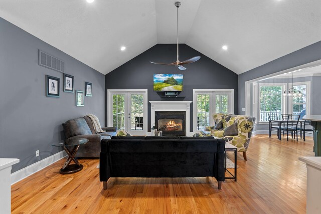 living room with ceiling fan, lofted ceiling, and light hardwood / wood-style flooring