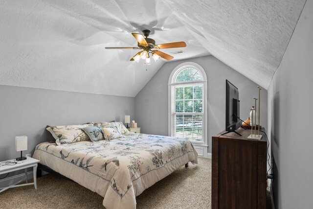 carpeted bedroom with a textured ceiling, ceiling fan, and lofted ceiling