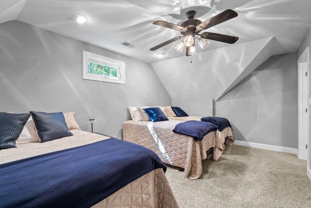 bedroom featuring a textured ceiling, ceiling fan, light carpet, and vaulted ceiling