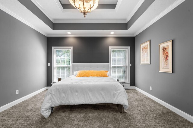 carpeted bedroom featuring a raised ceiling and crown molding