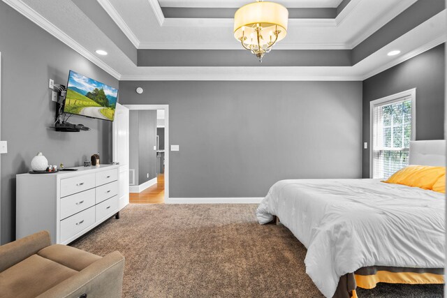 bedroom featuring a tray ceiling, carpet flooring, ornamental molding, and an inviting chandelier