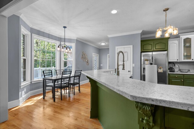 kitchen featuring a notable chandelier, green cabinetry, high end fridge, white cabinets, and ornamental molding