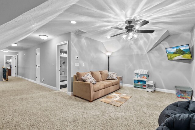 living room featuring ceiling fan, carpet floors, a textured ceiling, and vaulted ceiling