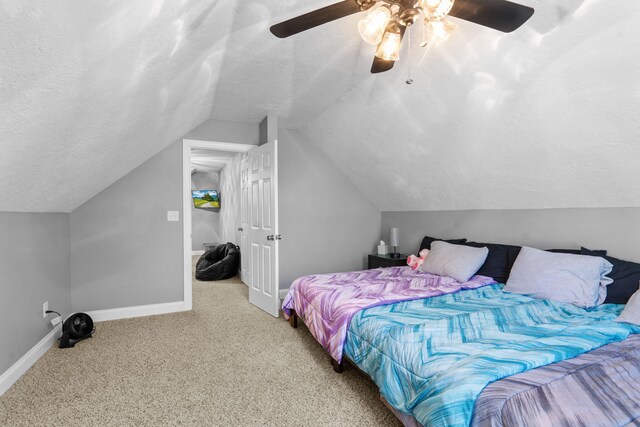 bedroom featuring carpet flooring, a textured ceiling, vaulted ceiling, and ceiling fan