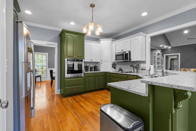 kitchen with white cabinets, green cabinets, sink, kitchen peninsula, and stainless steel appliances