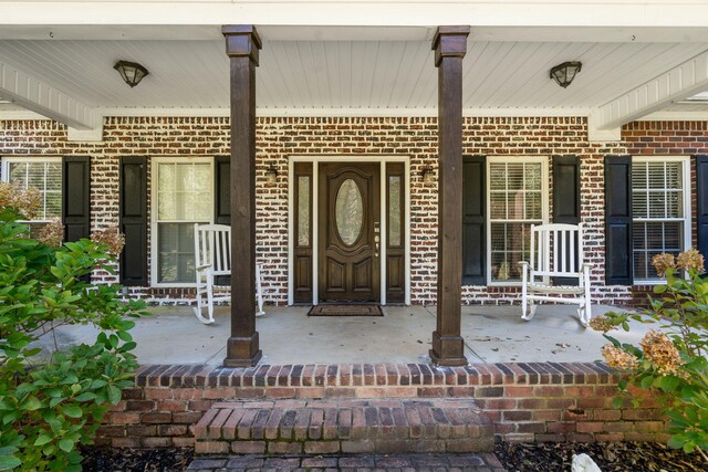 view of exterior entry featuring covered porch