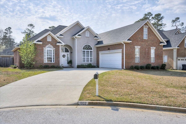 traditional home with brick siding, a front lawn, concrete driveway, and a garage