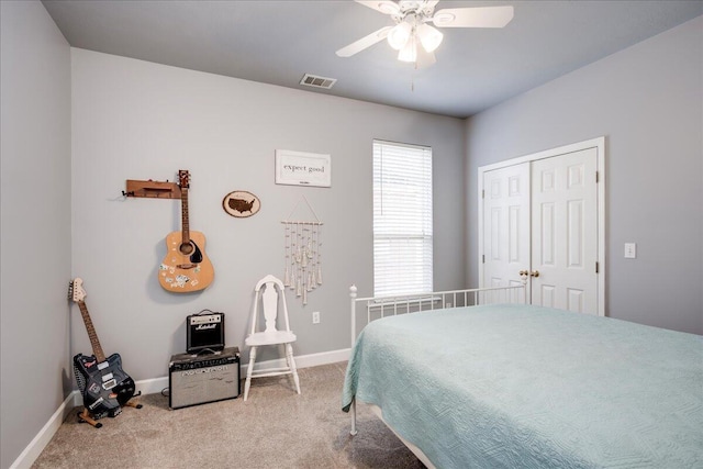 carpeted bedroom with a ceiling fan, baseboards, visible vents, and a closet