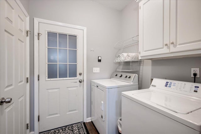 clothes washing area featuring washer and dryer and cabinet space