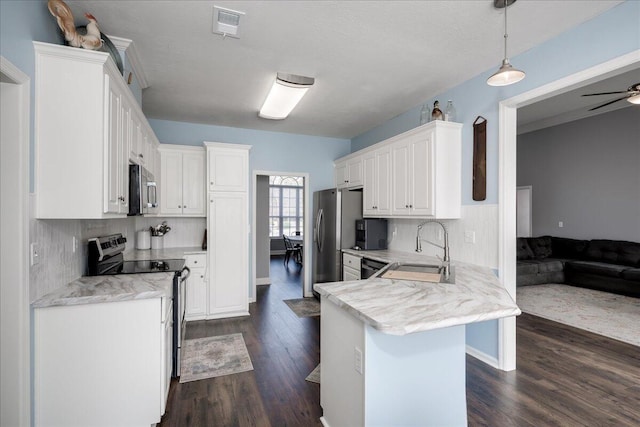 kitchen with visible vents, a sink, stainless steel appliances, dark wood-type flooring, and white cabinetry