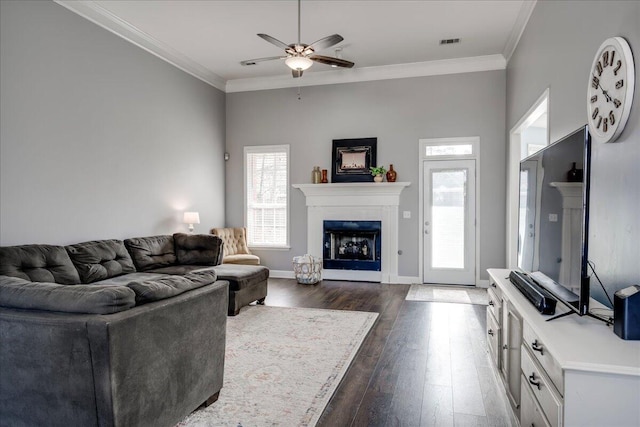 living room with visible vents, a fireplace, crown molding, and ceiling fan