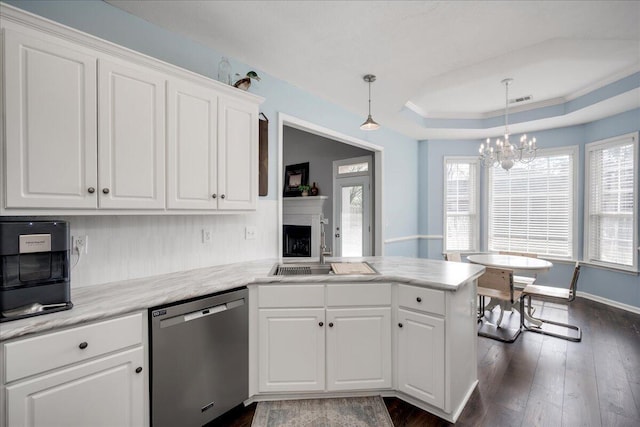 kitchen with a notable chandelier, dark wood finished floors, white cabinets, a raised ceiling, and dishwasher