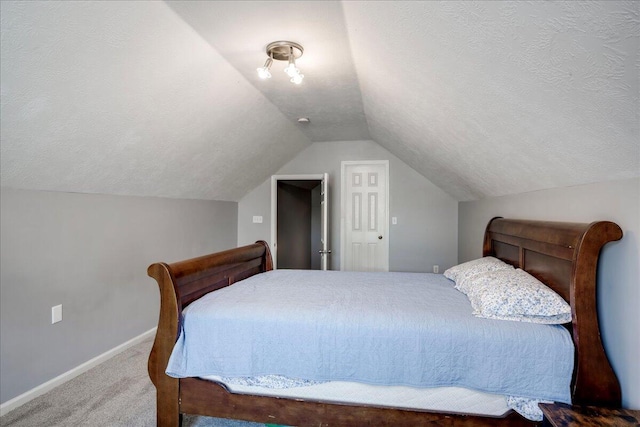 bedroom with vaulted ceiling, carpet, baseboards, and a textured ceiling