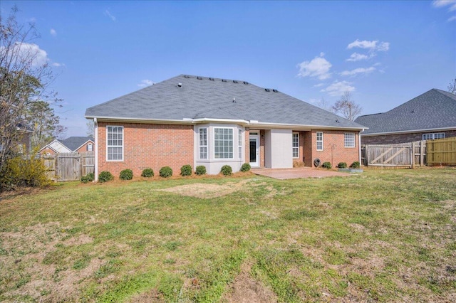 rear view of property with a gate, a lawn, and a fenced backyard