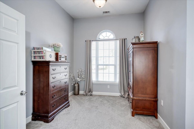 bedroom with baseboards, visible vents, and light carpet