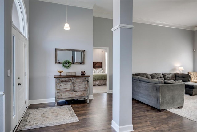 foyer with dark wood-type flooring, decorative columns, baseboards, and ornamental molding