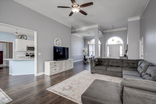 living room featuring dark wood-style floors, baseboards, ceiling fan, and crown molding