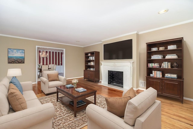 3134 Walton Way, Augusta, GA 30909 - living room featuring ornamental molding, light wood finished floors, a fireplace with flush hearth, a chandelier, and baseboards