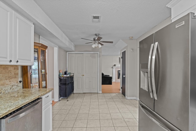 4375 Sandy Ridge Pl, Augusta, GA 30909 - kitchen featuring stainless steel appliances, a ceiling fan, white cabinetry, light tile patterned flooring, and decorative backsplash