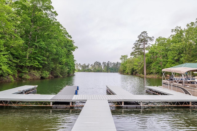 view of dock with a water view and a forest view