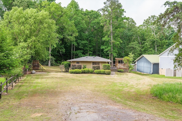 view of yard with a playground, an outdoor structure, and a deck