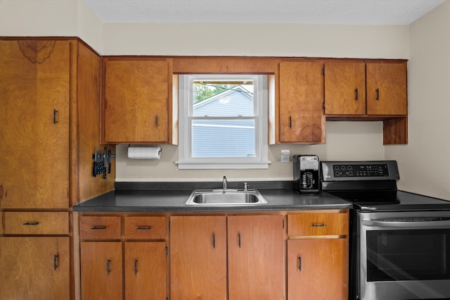 kitchen with brown cabinets, a sink, and stainless steel range with electric stovetop