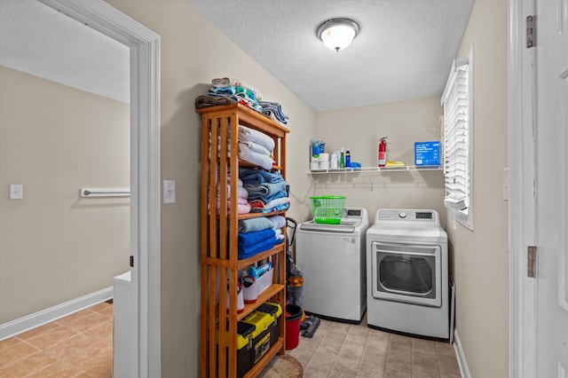 laundry area featuring laundry area, a textured ceiling, independent washer and dryer, and baseboards