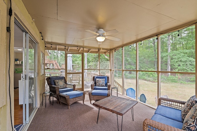 sunroom / solarium with plenty of natural light, a ceiling fan, and an outdoor hangout area