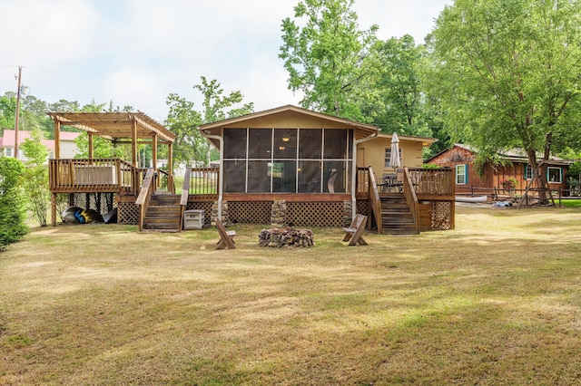 rear view of property featuring a deck, a sunroom, stairway, a yard, and a pergola