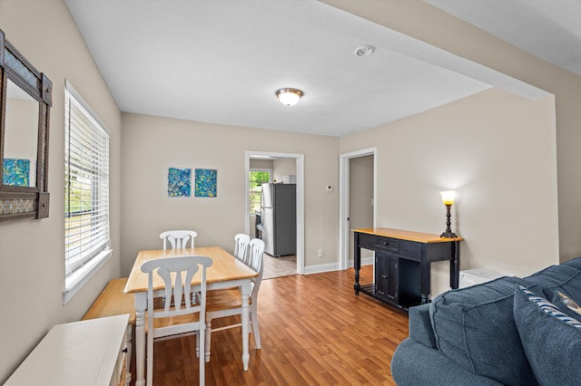 dining area with light wood-type flooring and baseboards