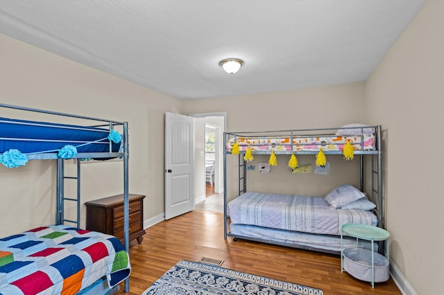 bedroom with baseboards and wood finished floors
