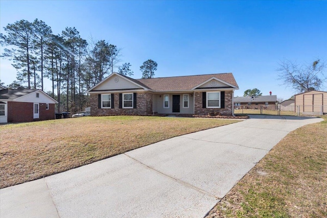 ranch-style house with driveway, a front lawn, fence, and brick siding