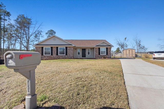 view of front of property featuring driveway, a front lawn, and brick siding