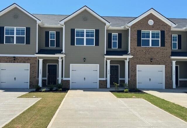 view of front of property with an attached garage, driveway, and brick siding
