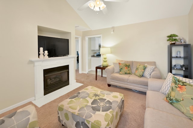 carpeted living room with ceiling fan and vaulted ceiling