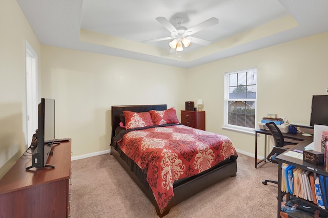 bedroom featuring carpet, ceiling fan, and a raised ceiling