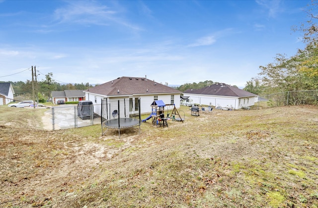 rear view of property with a trampoline