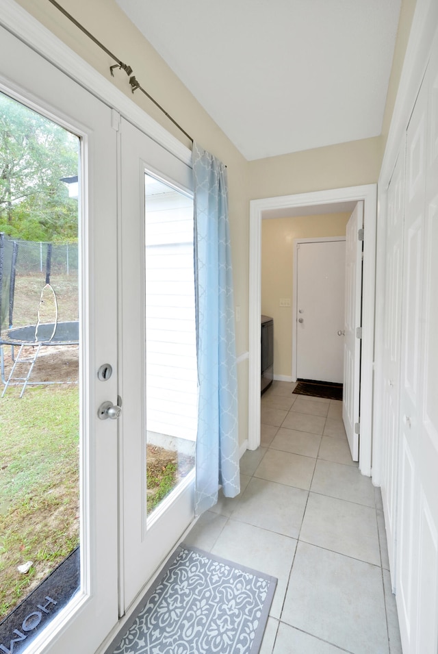 doorway featuring light tile patterned floors and a wealth of natural light