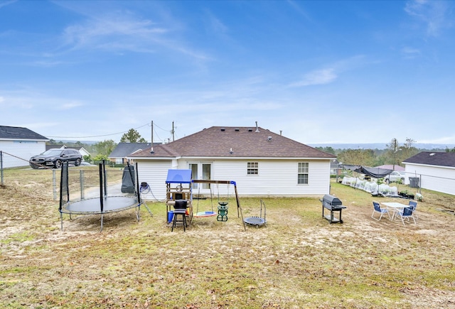 back of property featuring a trampoline