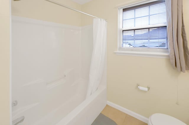 bathroom with tile patterned flooring, shower / bath combo, and toilet