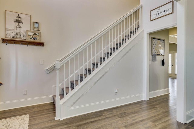 stairway with wood finished floors and baseboards