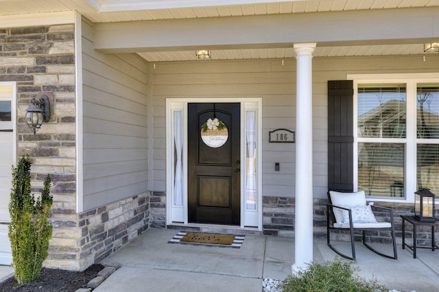 entrance to property featuring covered porch and stone siding