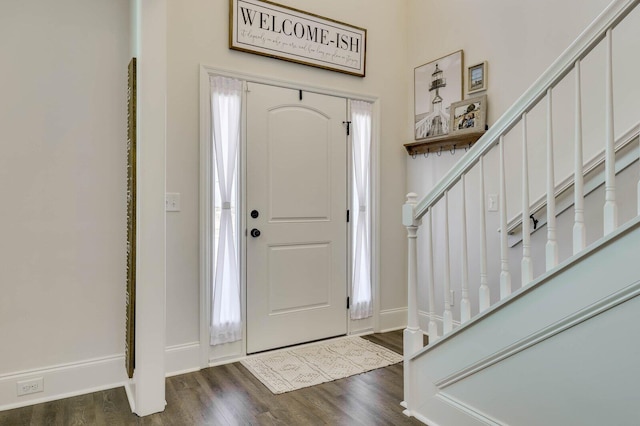 foyer entrance with baseboards, dark wood-style floors, and stairs