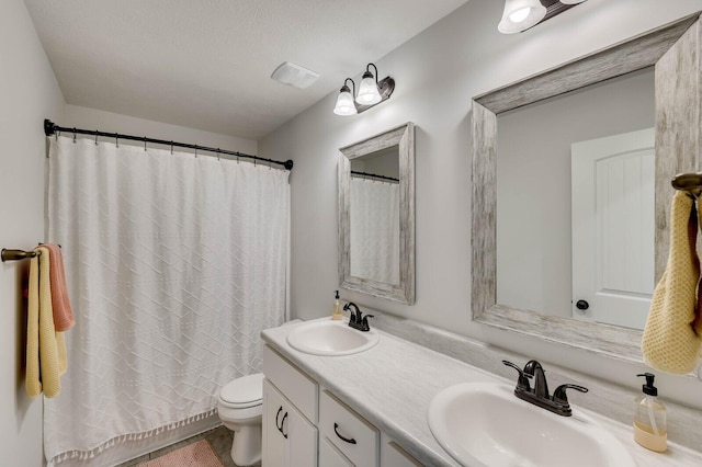 bathroom featuring a sink, curtained shower, toilet, and double vanity