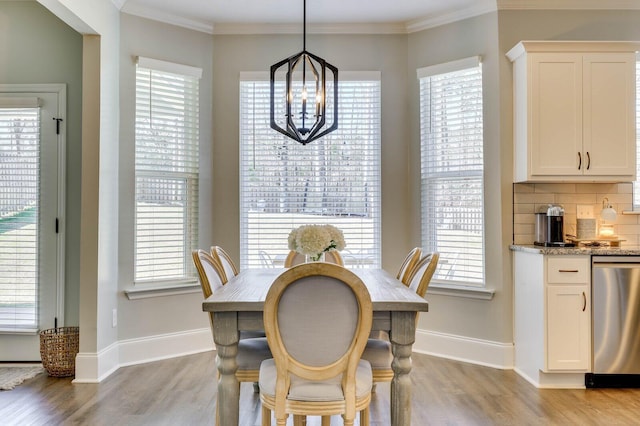 dining area with light wood finished floors, crown molding, and a wealth of natural light