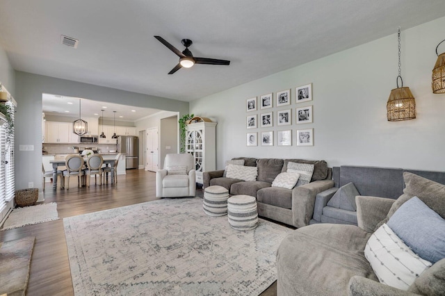 living room featuring recessed lighting, a ceiling fan, visible vents, and dark wood-style flooring