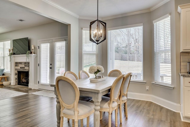 dining room featuring a healthy amount of sunlight, wood finished floors, baseboards, and ornamental molding